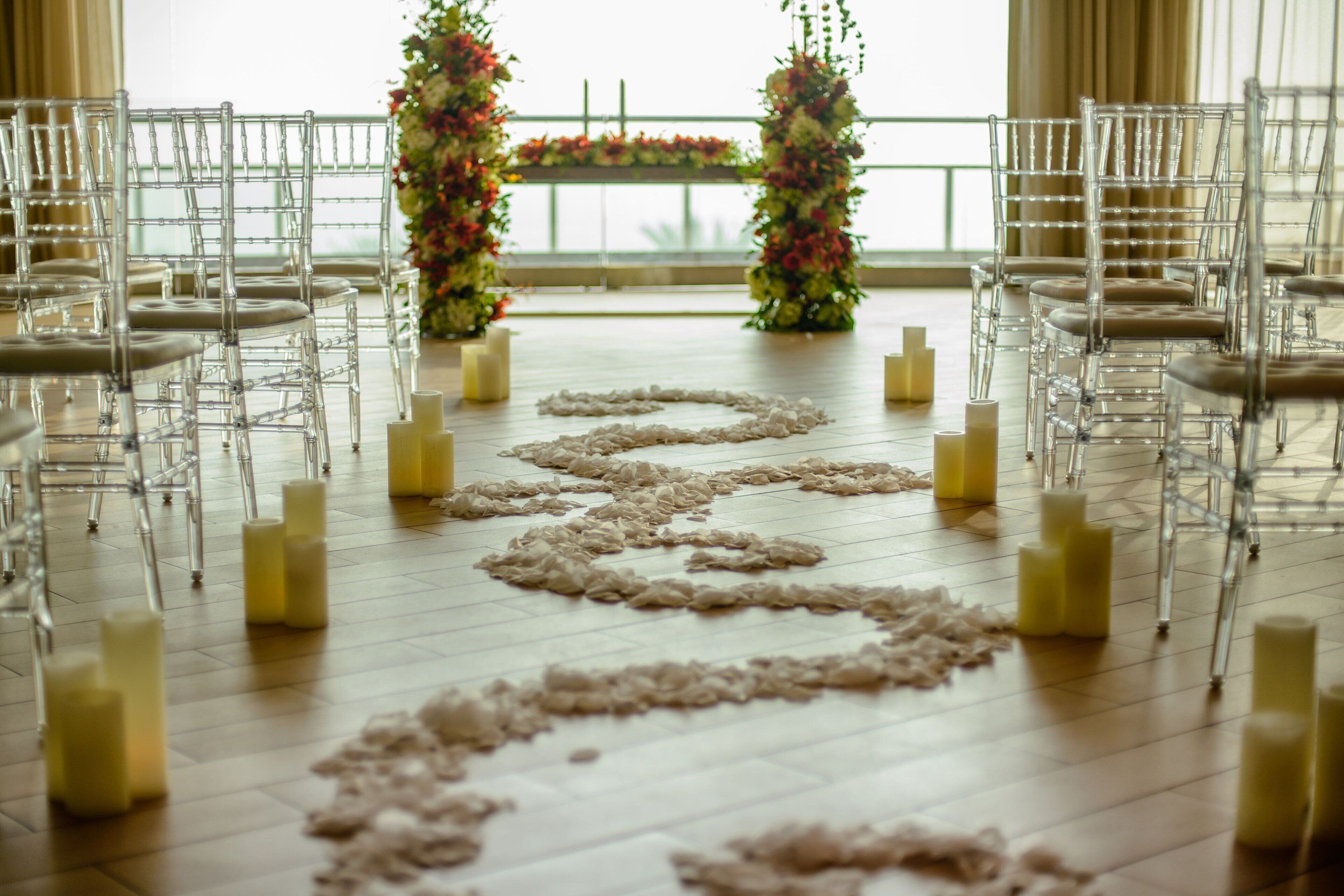 Una navata nuziale con sedie, candele e decorazioni floreali.