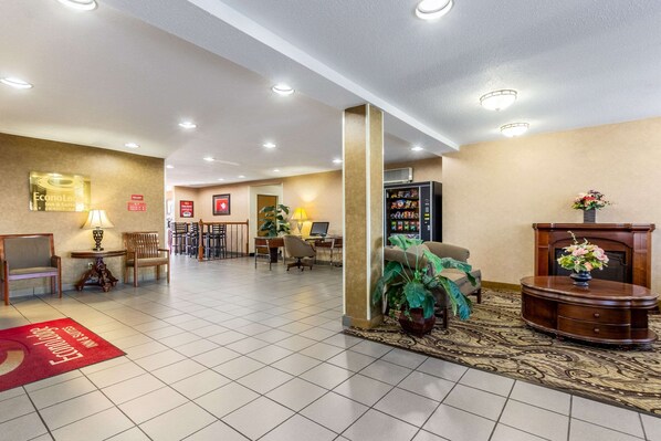 Un hall d’hôtel comprenant un comptoir d’accueil, un espace salon et une cheminée.
