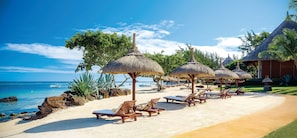 On the beach, white sand, sun loungers, beach umbrellas