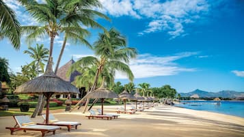 On the beach, white sand, sun loungers, beach umbrellas