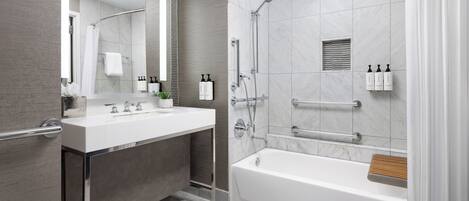 A modern bathroom with a bathtub, shower, and vanity.