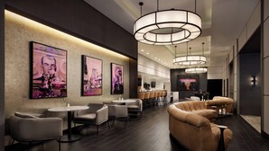 Un moderno vestíbulo de hotel con área de bar, distribuciones de asientos y obras de arte en las paredes.