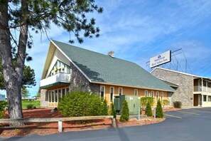 A building with a stone facade, a green roof, and a sign for 'Americas Best Value Inn'.