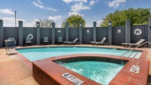 Piscina com hidromassagem, espreguiçadeiras e área cercada.
