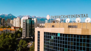 Un bâtiment moderne, sur lequel on peut voir une enseigne indiquant « Intercontinental Hotel ». Il se distingue par sa façade en verre et les nombreuses antennes paraboliques qui ornent son toit.