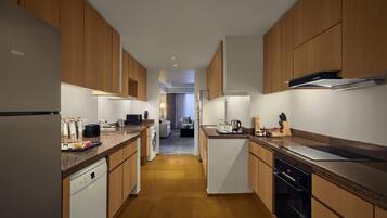 Una cocina moderna con armarios de madera, lavavajillas, estufa y pileta.