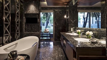 A modern bathroom with a freestanding bathtub, a large vanity with a sink, and a mirror.