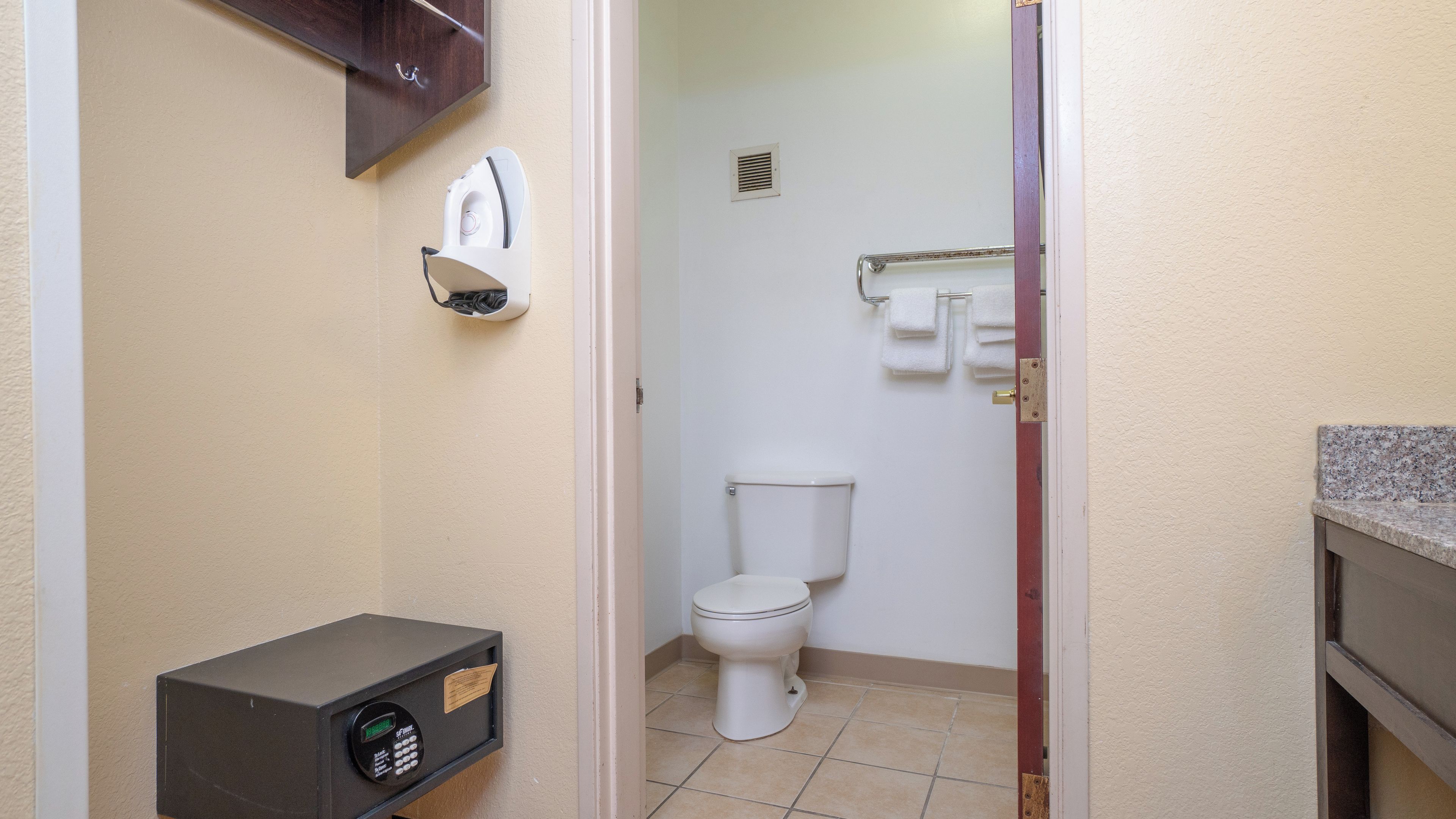 Ein Badezimmer mit Toilette, Handtuchspender und Seifenspender.