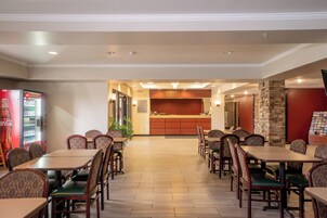 A hotel lobby with a reception desk, seating area, and vending machines.