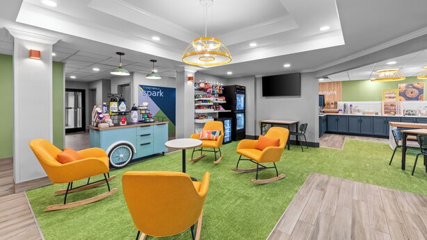 A children's play area with colorful chairs, a snack bar, and a toy display. - Spark by Hilton Cincinnati Airport South (Florence)