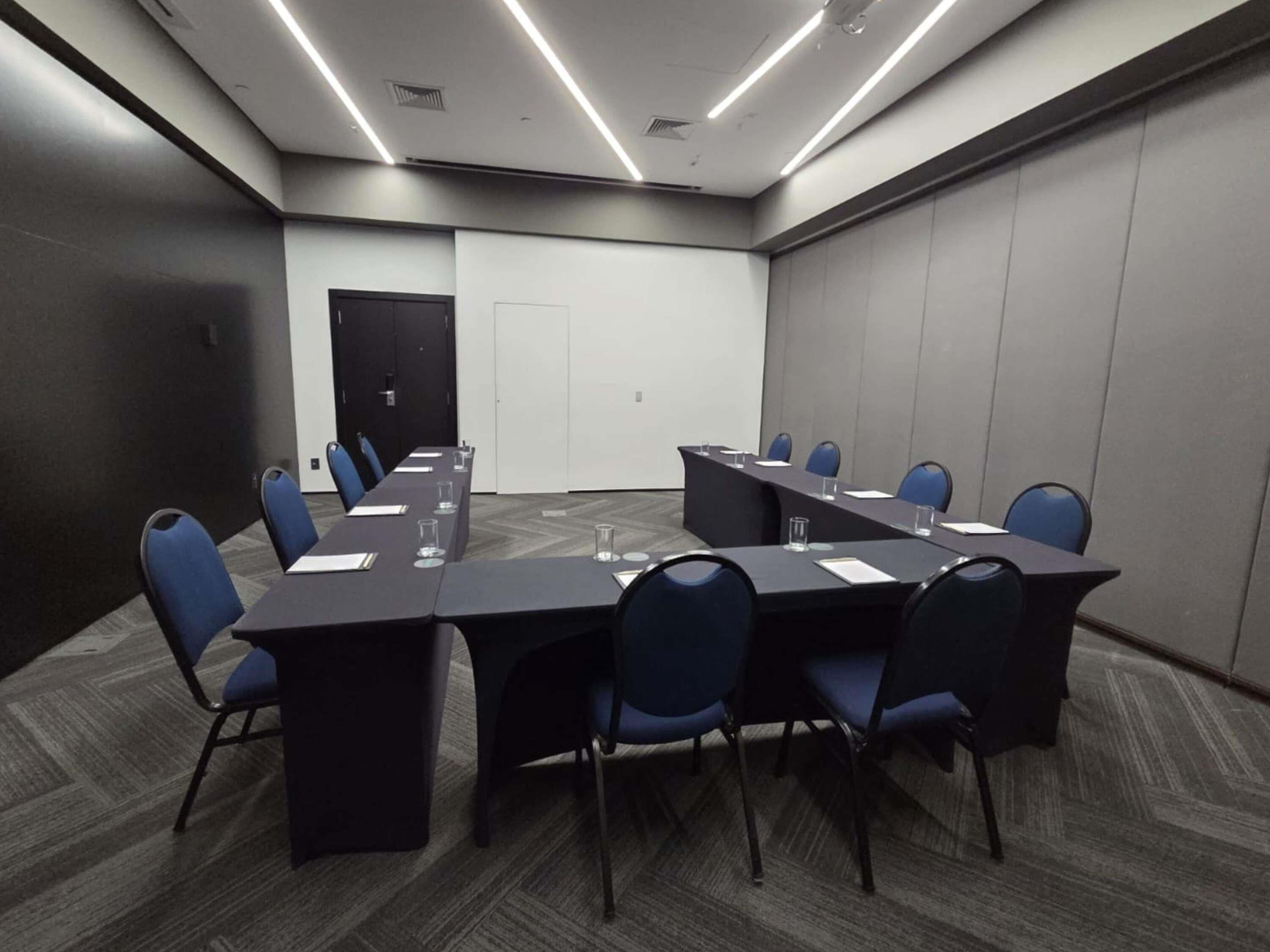 A conference room with a long table, chairs, and a whiteboard.