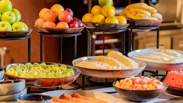 Um buffet com diversas frutas e legumes.