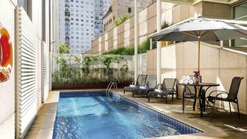 Een buitenzwembad en ligstoelen