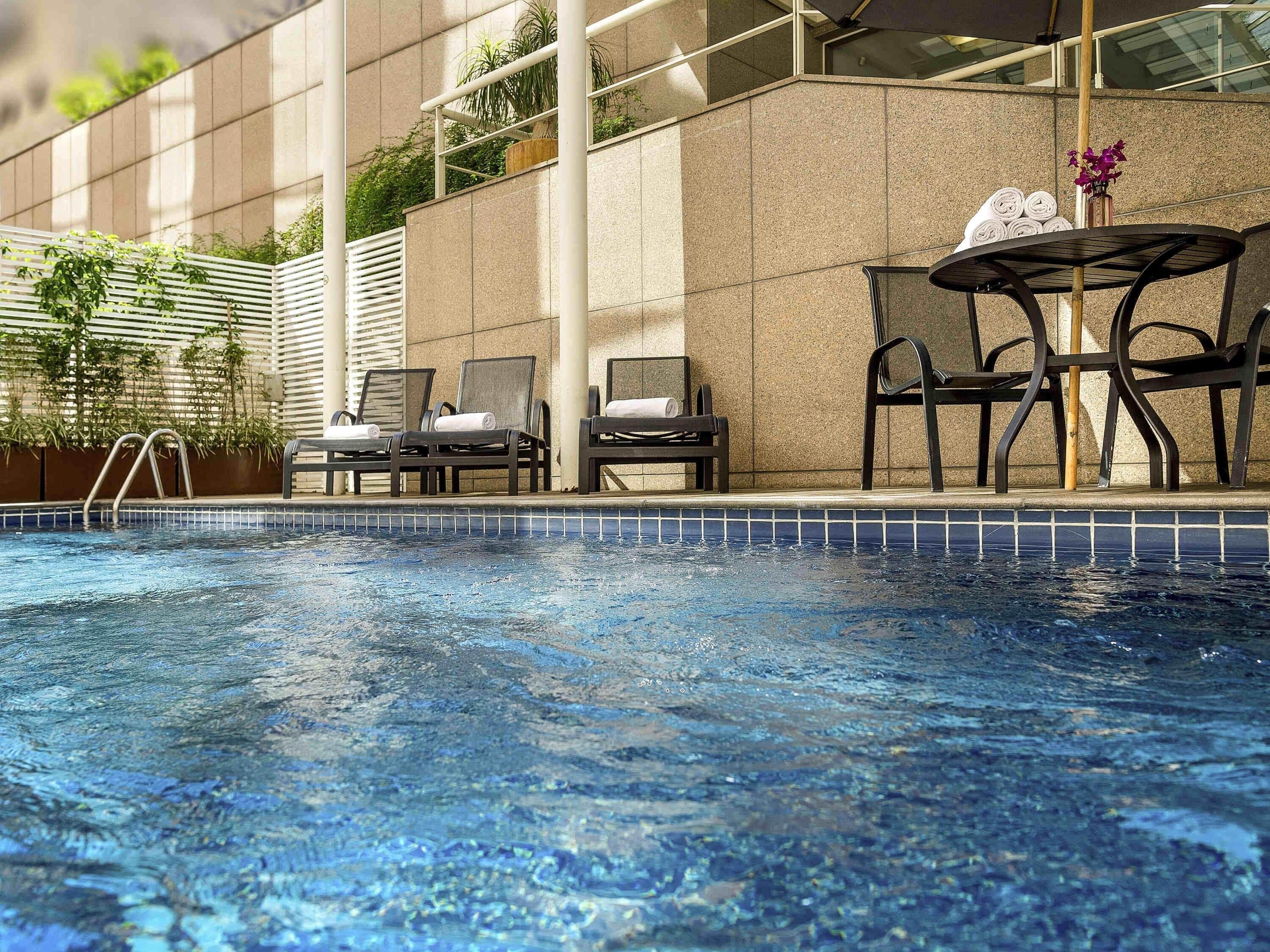 Una piscina al aire libre, sillones reclinables de piscina