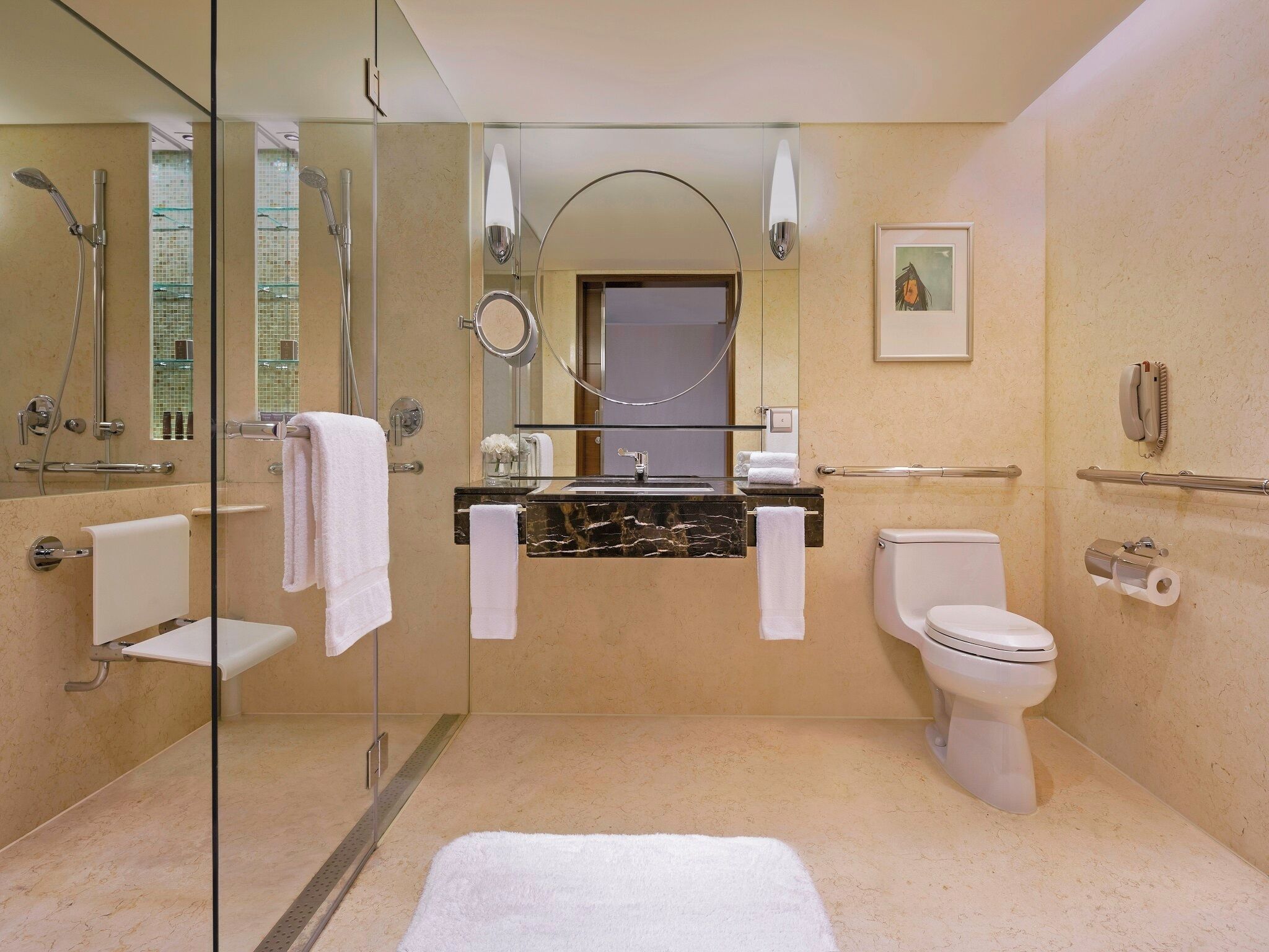 A modern bathroom with a glass shower enclosure, a marble sink, a toilet, and a glass partition.