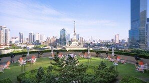 A rooftop garden with outdoor seating and a view of a city skyline. - The Portman Ritz-Carlton, Shanghai (Shanghai)