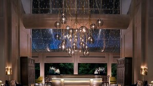 Un'elegante hall con un grande lampadario, un'area bar e comode sedute.