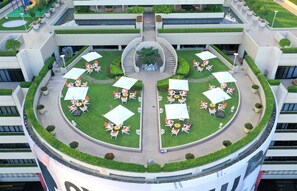A circular outdoor area with multiple seating arrangements, a central staircase, and surrounding greenery. - The Portman Ritz-Carlton, Shanghai (Shanghai)