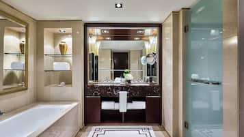 A modern bathroom with a large mirror, a bathtub, and a glass shower enclosure.