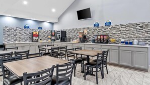 A modern restaurant with a counter, seating area, and a ceiling fan. - Days Inn by Wyndham Simpsonville (Simpsonville)