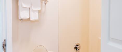 A bathroom with a toilet, a bathtub, and a shower.