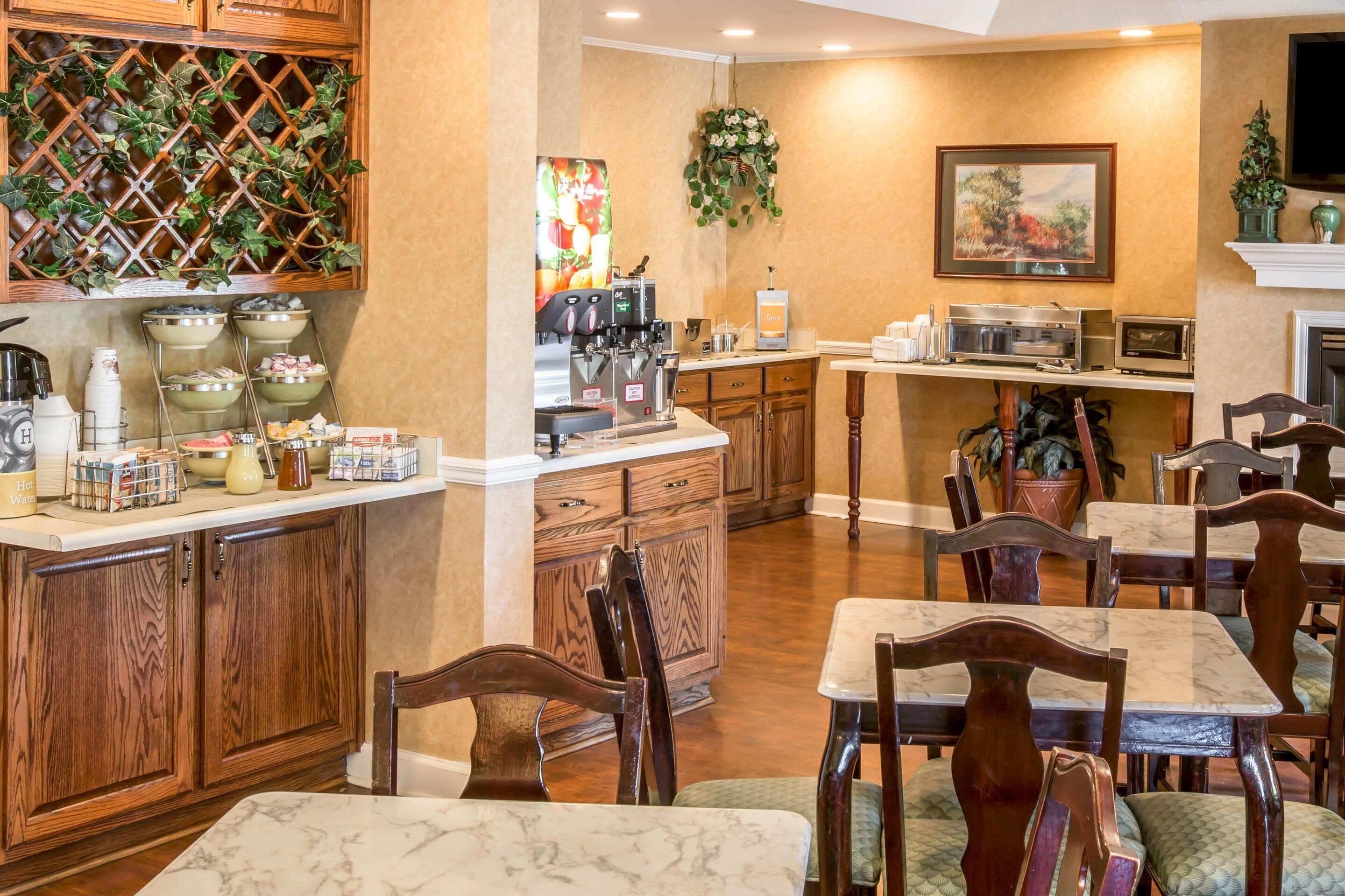 A kitchen with a coffee machine, tea station, and wooden cabinets.