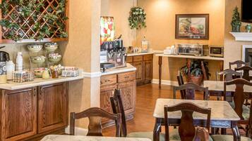 A kitchen with a coffee machine, tea station, and wooden cabinets.