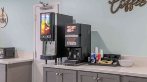 Une machine à café dotée d’un écran numérique, un four à micro-ondes et un élément de décoration murale sur le thème du café.