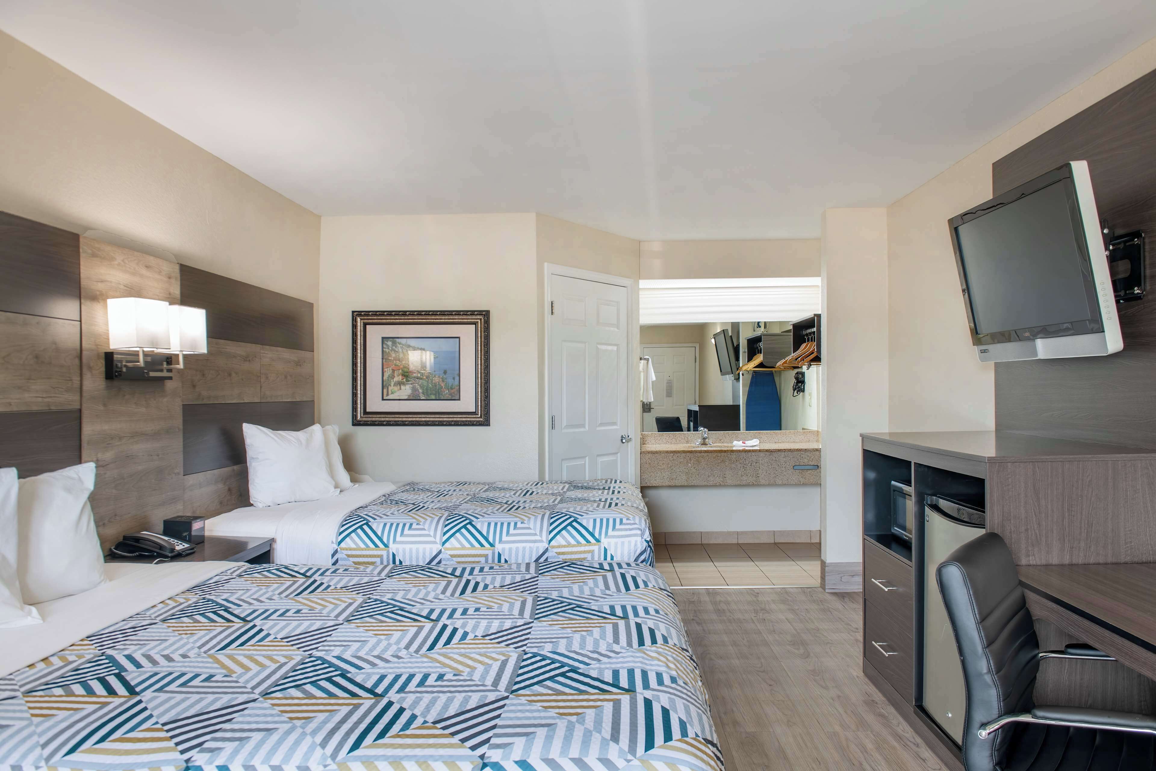 Senger med overmadrass, safe på rommet, skrivebord og blendingsgardiner