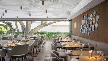 Un restaurant doté d’une grande salle à manger, de murs en bois et d’un plafond orné d’un motif élaboré.