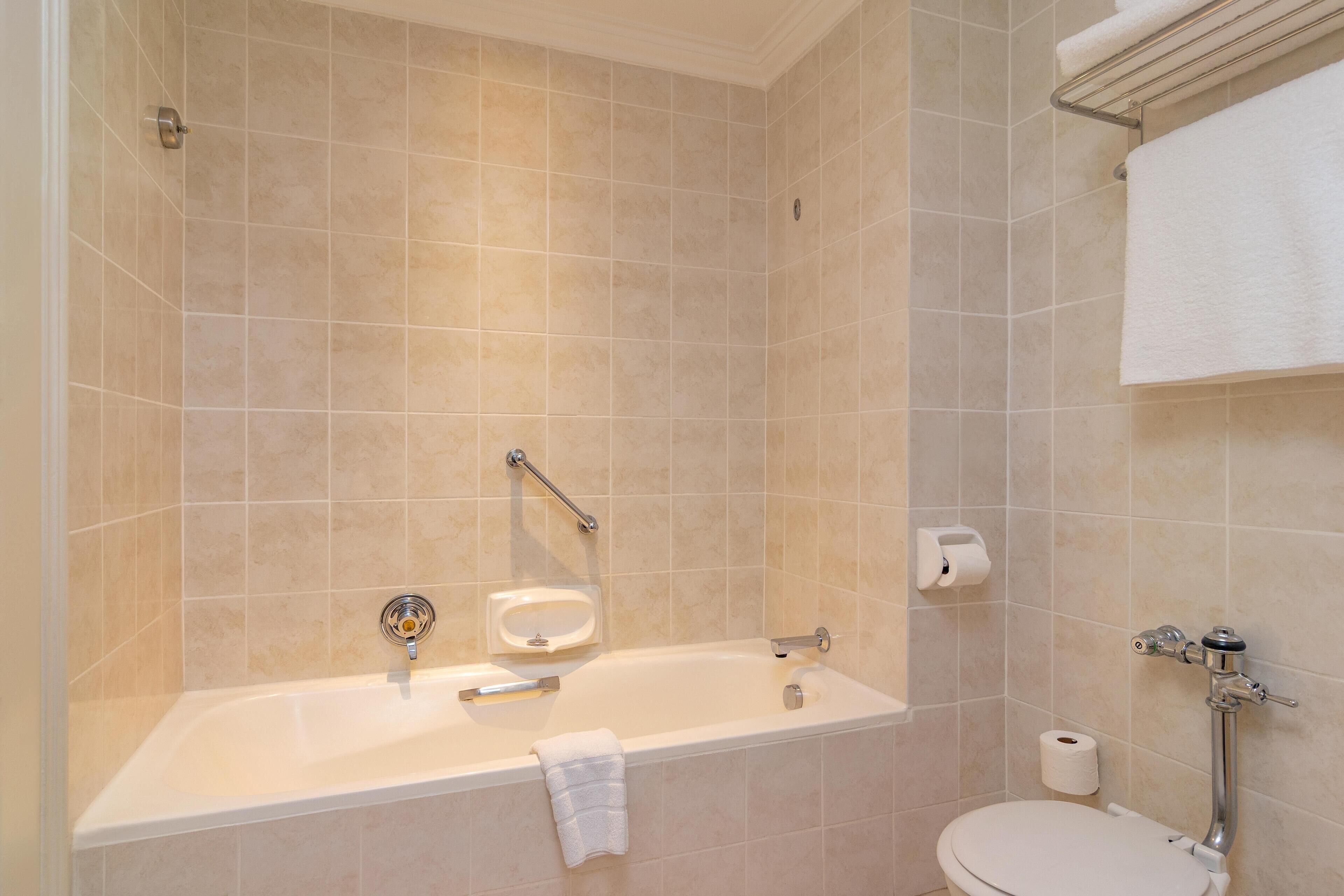 Une salle de bain avec une baignoire, des toilettes et un porte-serviettes.