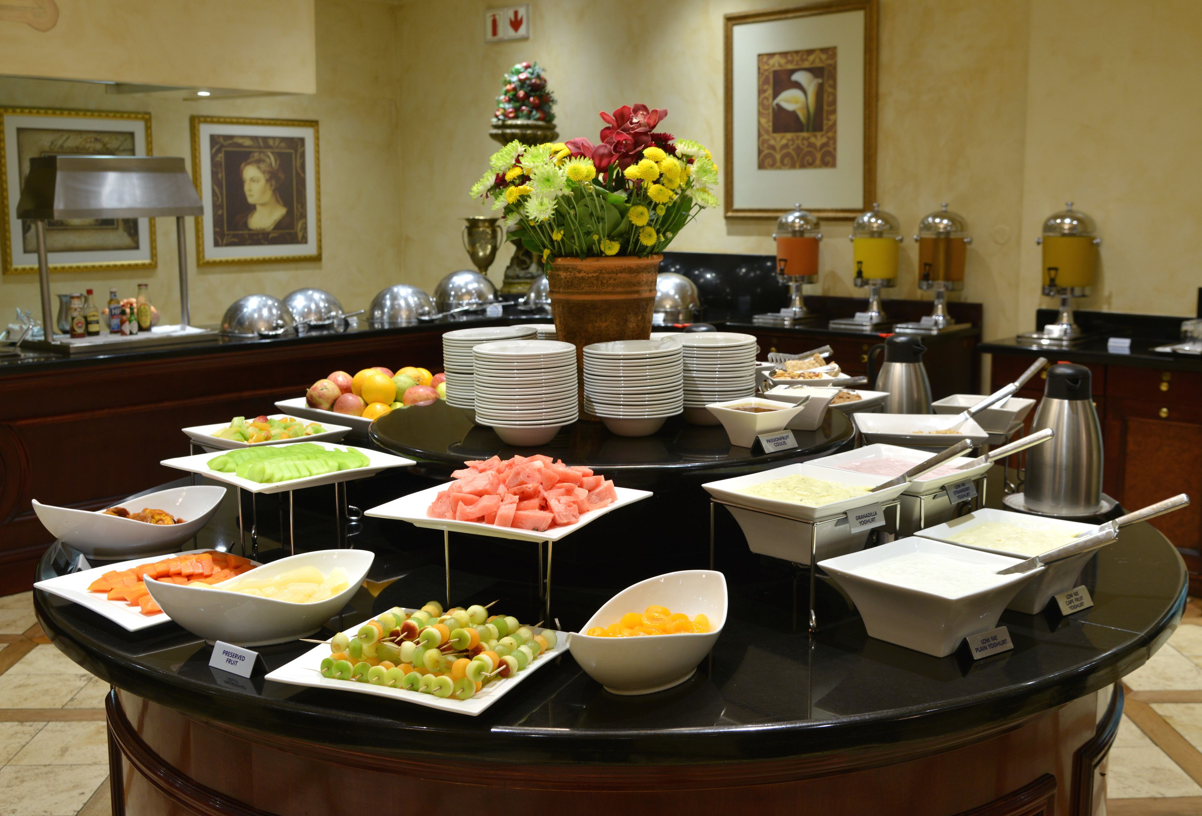 A buffet with various food items and a centerpiece of flowers.
