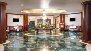 A lobby with a chandelier, a reception desk, and a staircase. - The Edward Hotel (Durban)