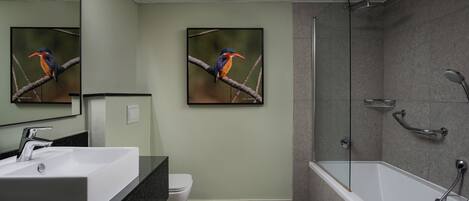 A modern bathroom with a large sink, toilet, and walk-in shower.