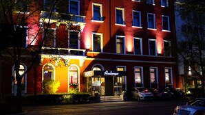 A hotel with a red facade, multiple windows, and a sign that reads "Amberger." - Hotel Amberger (Würzburg)