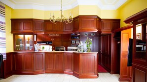A spacious kitchen with wooden cabinetry, a central island, and a chandelier. - Hotel Amberger (Würzburg)