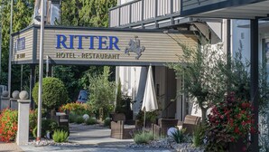 A hotel named Ritter with a signboard, outdoor seating area, and potted plants. -  Hotel Ritter Badenweiler (Badenweiler)