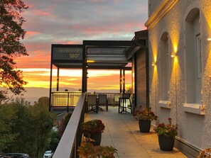 A terrace with a sunset view, outdoor seating, and potted plants. - Hotel Ritter Badenweiler (Badenweiler)