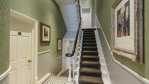 A staircase with a checkered floor leading to a door marked '16'. - Kensington Gardens Hotel (London)
