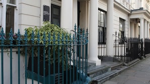A hotel facade with classical architecture, including columns and a sign indicating it is a hotel. - Kensington Gardens Hotel (London)