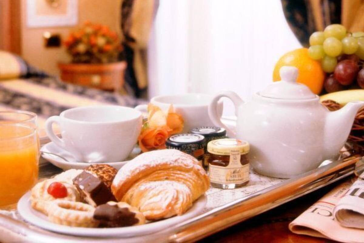Una bandeja con pastelería, té y fruta para el desayuno.
