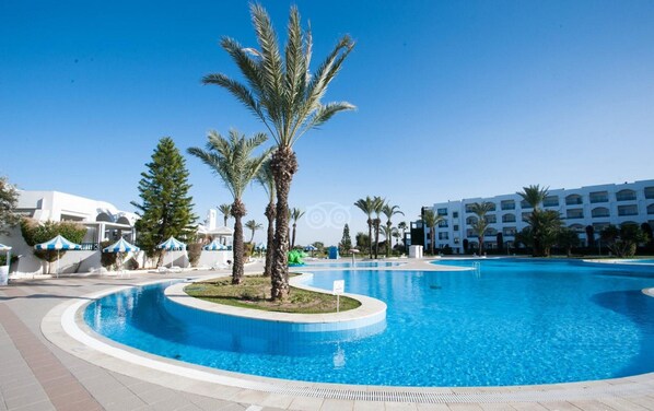 Piscine couverte, piscine extérieure, parasols de plage, chaises longues