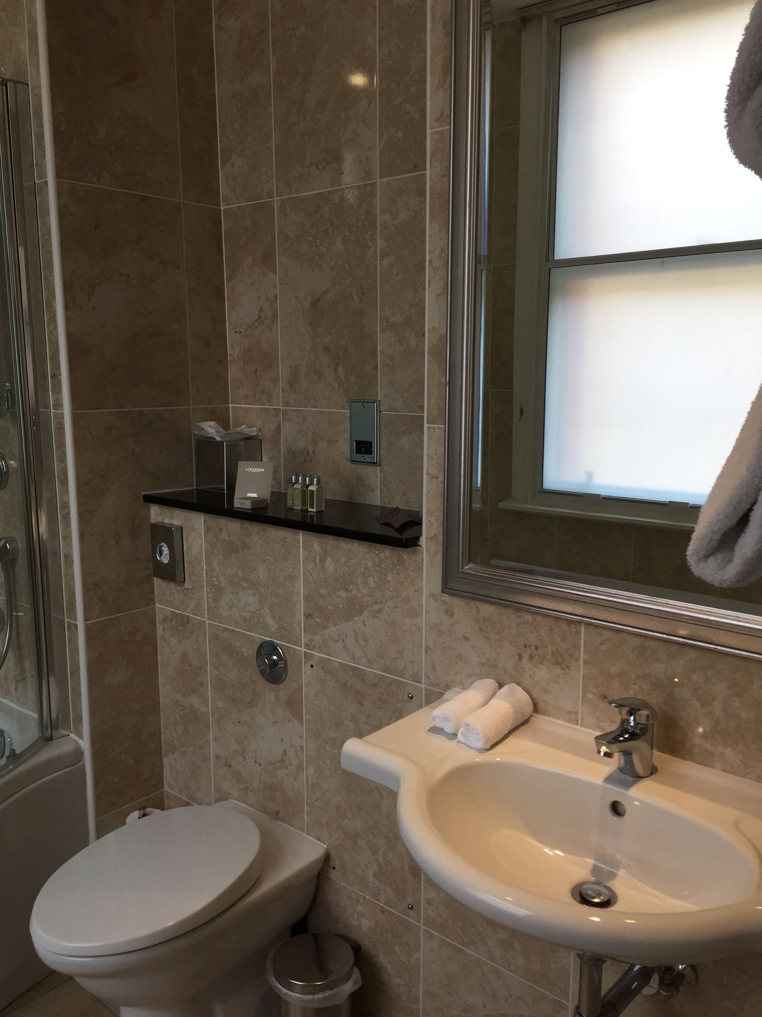 A bathroom with a toilet, sink, and shower.