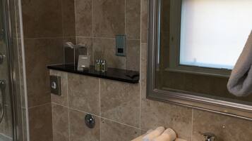 A bathroom with a toilet, sink, and shower.