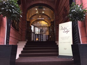 The entrance to The Porters Lodge with a signboard listing amenities like cocktails, wines, ales, specialty savouries, and afternoon teas.
