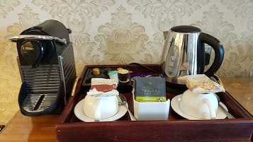 Un plateau avec une machine à café, une bouilloire et un service à thé.