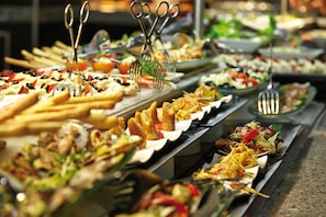 A buffet with various dishes and utensils. - Hotel Riu Palace Macao - Adults Only - All Inclusive (Punta Cana)