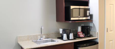 Cocina compacta con fregadero, microondas, cafetera y lavavajillas.