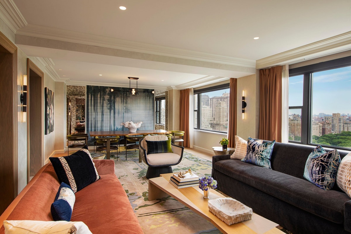 Een moderne woonkamer met een bank, fauteuil en een eethoek.