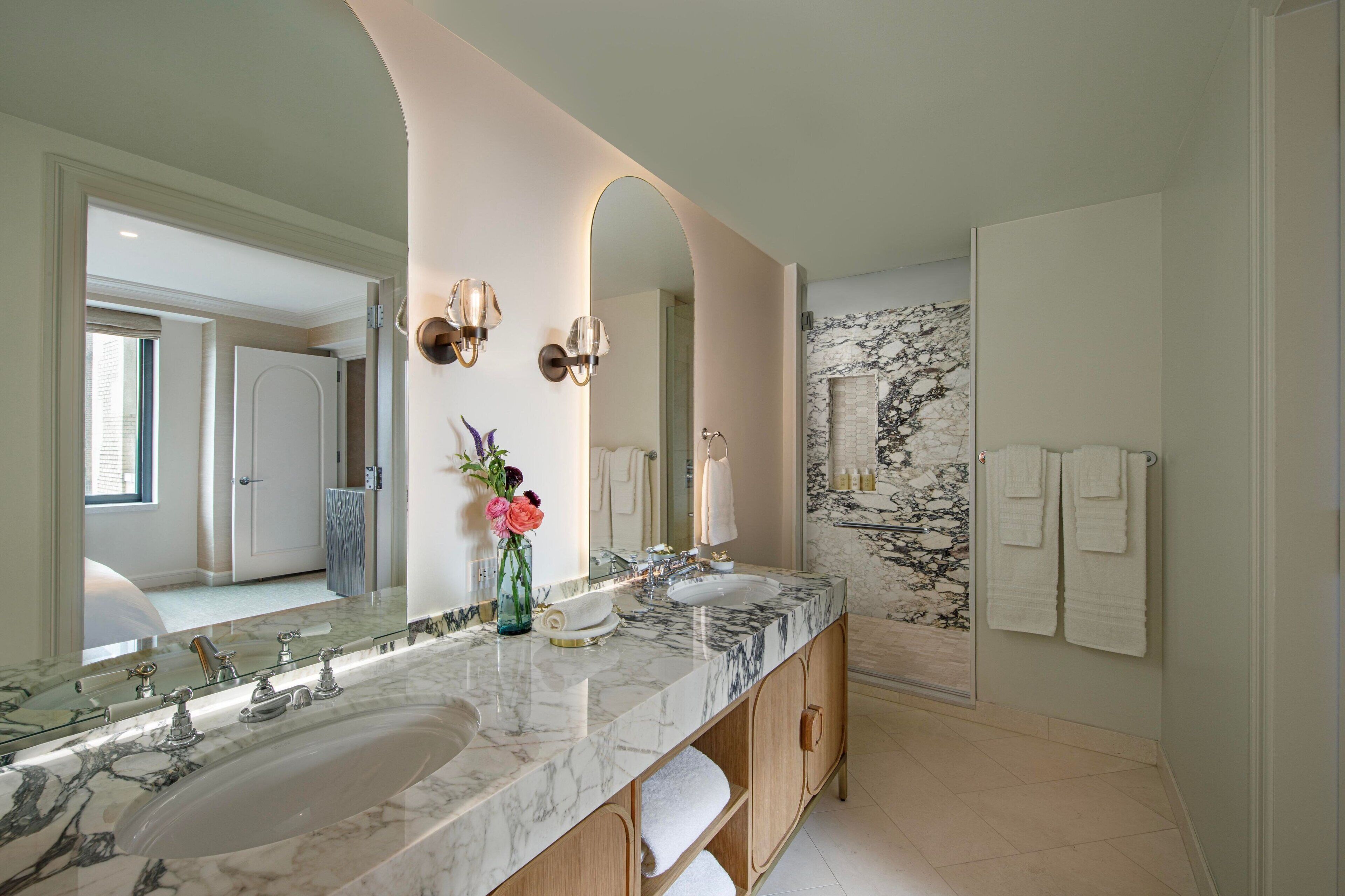 A bathroom with two sinks, a large mirror, and a marble countertop.